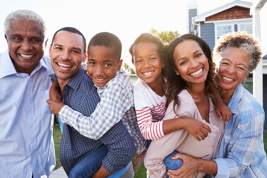 Personal Insurance - Happy Portrait of Extended Family Standing Outside Their Home