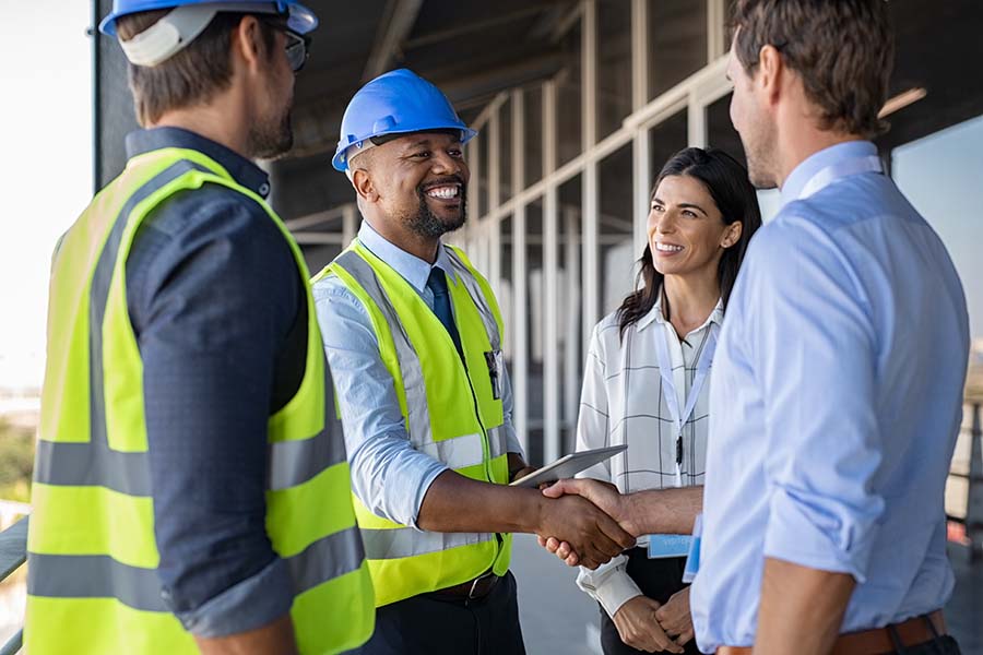 Specialized Business Insurance - Two Engineers Shaking Hands WIth Clients At A Construction Jobsite